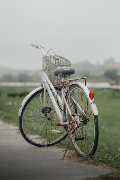 a white bicycle parked on the side of a road